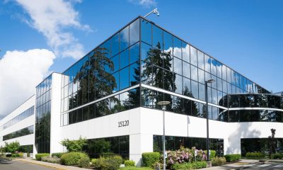 Contemporary office building in Redmond with reflective glass and lush greenery, captured on a sunny day.
